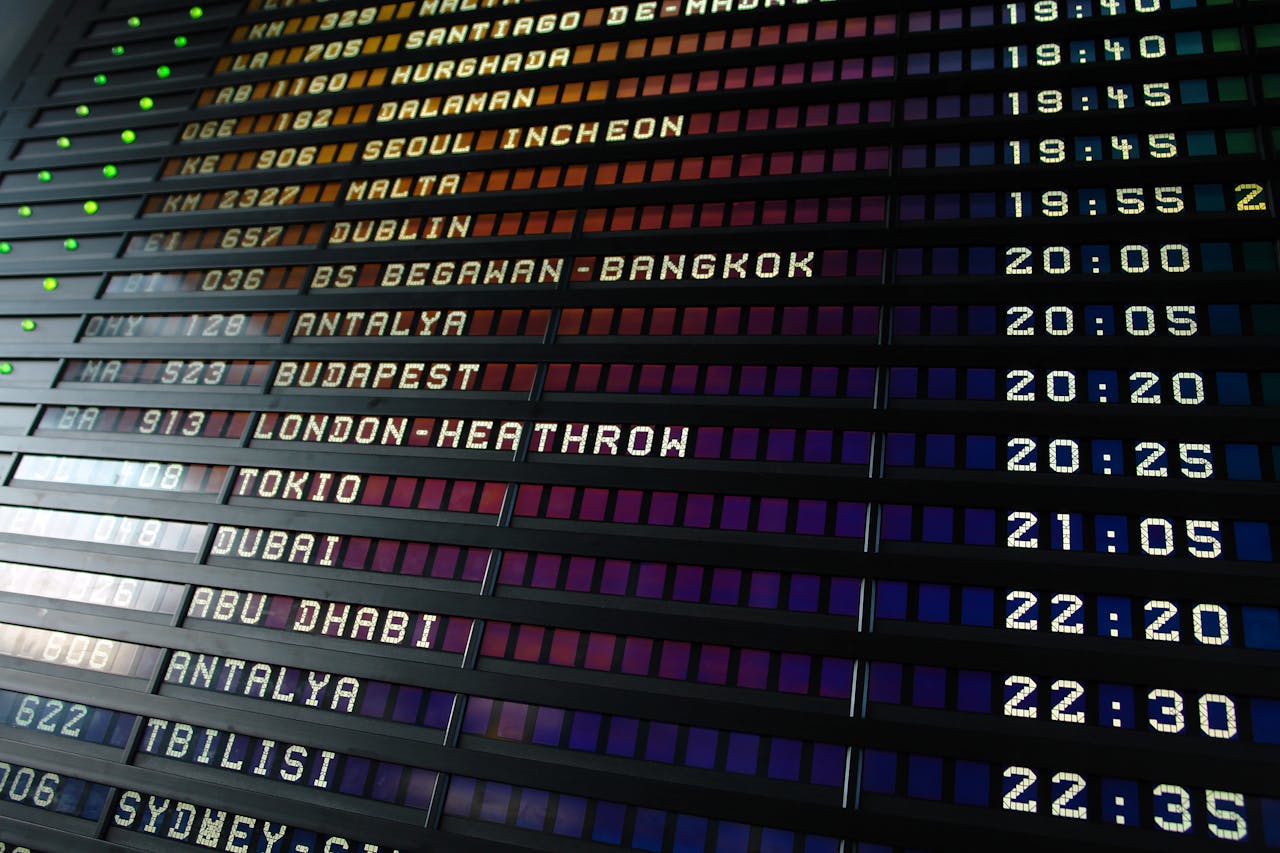 Retro flip-style airport departure board showing international flight destinations and times.